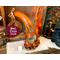 A handcrafted pumpkin gourd named Uncle Dub. It is a tall gourd leaning towards the left decorated with fall leaves and dried berries.